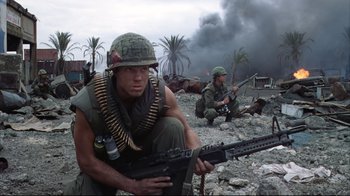 Movie still from “Full Metal Jacket” (1987), directed by Stanley Kubrick – Two men in fatigues are sitting on the rocks; Medium shot, Low angle