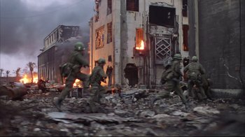 Movie still from “Full Metal Jacket” (1987), directed by Stanley Kubrick – A group of soldiers running through a destroyed city; Wide shot, Low angle