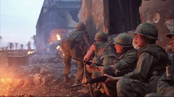 Movie still from “Full Metal Jacket” (1987), directed by Stanley Kubrick – A group of soldiers sitting on a pile of rubble; Wide shot, Low angle