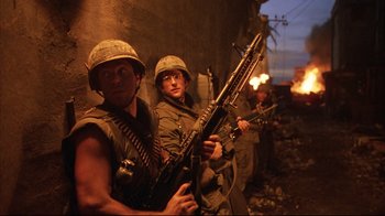 Movie still from “Full Metal Jacket” (1987), directed by Stanley Kubrick – A group of men standing next to each other holding guns; Medium shot, Low angle