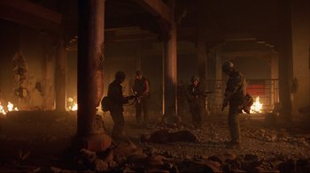 Movie still from “Full Metal Jacket” (1987), directed by Stanley Kubrick – A group of men standing next to each other in the dark; Wide shot, High angle