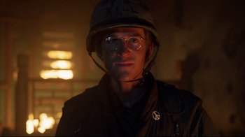 Movie still from “Full Metal Jacket” (1987), directed by Stanley Kubrick – A man wearing a helmet and glasses in the dark; Close Up shot, Low angle