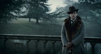 Movie still from “The Wolfman” (2010), directed by Joe Johnston – A man in a hat and coat holding a cane; Medium shot, Low angle