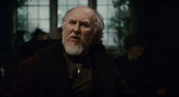 Movie still from “The Wolfman” (2010), directed by Joe Johnston – An old man with a beard and a long white beard; Close Up shot, Over the shoulder angle