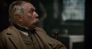 Movie still from “The Wolfman” (2010), directed by Joe Johnston – An older man sitting in a chair looking off into the distance; Close Up shot, Low angle