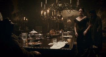 Movie still from “The Wolfman” (2010), directed by Joe Johnston – A woman standing in front of a table with food on it; Wide shot, Over the shoulder angle
