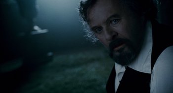 Movie still from “The Wolfman” (2010), directed by Joe Johnston – A person wearing a suit and beard; Close Up shot, Over the shoulder angle