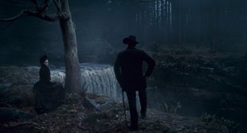 Movie still from “The Wolfman” (2010), directed by Joe Johnston – A man standing in front of a waterfall in the dark; Wide shot, Over the shoulder angle