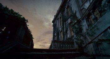 Movie still from “The Wolfman” (2010), directed by Joe Johnston – A view of a building from the ground looking up at the sky at dusk; Extreme Wide shot, Low angle