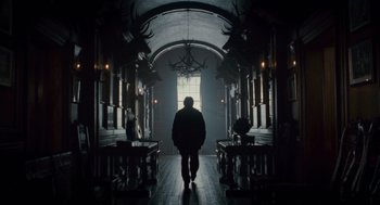 Movie still from “The Wolfman” (2010), directed by Joe Johnston – A man walking down a hall way in a dark room; Wide shot, Low angle