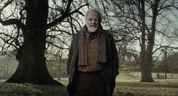 Movie still from “The Wolfman” (2010), directed by Joe Johnston – An older man standing in front of a large tree; Medium shot, Low angle