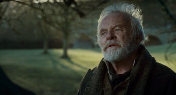 Movie still from “The Wolfman” (2010), directed by Joe Johnston – An older man with a beard and a scarf around his neck looks into the distance; Close Up shot, Low angle