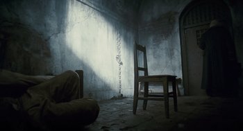 Movie still from “The Wolfman” (2010), directed by Joe Johnston – A chair and a couch in a dimly - lit room; Wide shot, High angle
