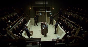 Movie still from “The Wolfman” (2010), directed by Joe Johnston – A group of men in suits and ties sitting in a room; Wide shot, High angle