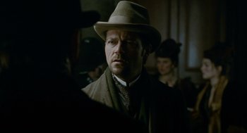 Movie still from “The Wolfman” (2010), directed by Joe Johnston – A man wearing a hat and a suit; Close Up shot, Over the shoulder angle