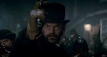 Movie still from “The Wolfman” (2010), directed by Joe Johnston – A person holding a gun in a room; Close Up shot, Over the shoulder angle