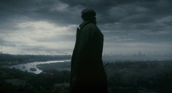 Movie still from “The Wolfman” (2010), directed by Joe Johnston – A man standing on top of a hill looking out at a city; Wide shot, Over the shoulder angle