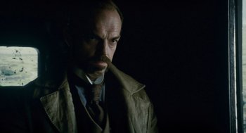 Movie still from “The Wolfman” (2010), directed by Joe Johnston – A person wearing a suit and tie; Close Up shot, Low angle