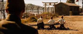 Movie still from “The Wolverine” (2013), directed by James Mangold – A group of people sitting on the beach; Wide shot, Over the shoulder angle