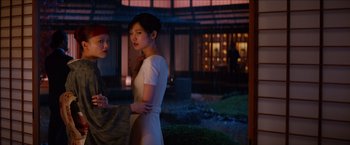 Movie still from “The Wolverine” (2013), directed by James Mangold – A woman standing next to another woman in a garden; Medium shot, Low angle
