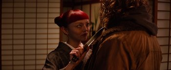 Movie still from “The Wolverine” (2013), directed by James Mangold – A woman with red hair holding a large knife; Close Up shot, Over the shoulder angle