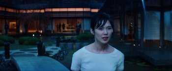 Movie still from “The Wolverine” (2013), directed by James Mangold – A woman in a white dress standing in front of a building at night; Medium shot, Over the shoulder angle