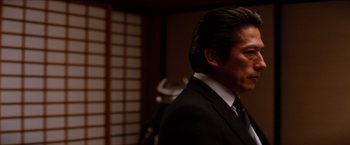 Movie still from “The Wolverine” (2013), directed by James Mangold – A person wearing a suit and tie; Close Up shot, Over the shoulder angle