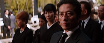Movie still from “The Wolverine” (2013), directed by James Mangold – A group of people wearing suits and ties standing next to each other; Close Up shot, Low angle