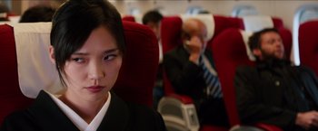 Movie still from “The Wolverine” (2013), directed by James Mangold – A woman sitting on a red seat on an airplane; Close Up shot, Over the shoulder angle