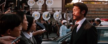 Movie still from “The Wolverine” (2013), directed by James Mangold – A man and a woman are talking in front of a crowd; Medium shot, Over the shoulder angle