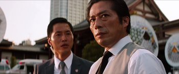 Movie still from “The Wolverine” (2013), directed by James Mangold – Two men in suits and ties standing next to each other; Close Up shot, Low angle