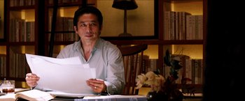 Movie still from “The Wolverine” (2013), directed by James Mangold – A man sitting at a table with papers in front of him; Close Up shot, Over the shoulder angle