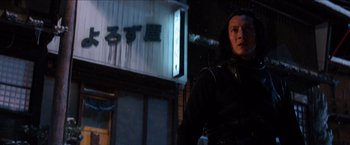 Movie still from “The Wolverine” (2013), directed by James Mangold – A woman standing in front of a building at night; Medium shot, Low angle