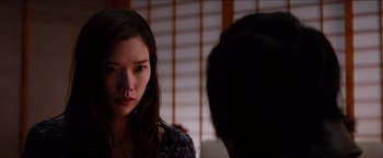 Movie still from “The Wolverine” (2013), directed by James Mangold – A young woman looking at the camera while a young man looks on; Close Up shot, Over the shoulder angle