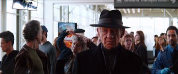 Movie still from “The Wolverine” (2013), directed by James Mangold – An old man wearing a black hat and a black suit; Close Up shot, Over the shoulder angle