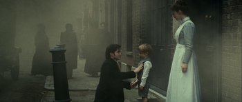 Movie still from “The Woman in Black” (2012), directed by James Watkins – A man and a boy in the middle of a street; Medium shot, Over the shoulder angle