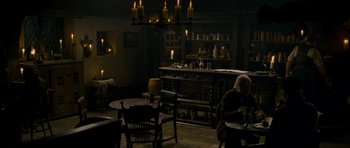 Movie still from “The Woman in Black” (2012), directed by James Watkins – A man sitting at a table in front of candles; Wide shot, High angle