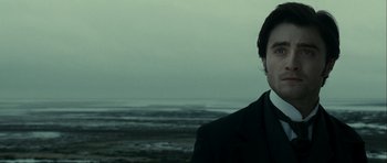 Movie still from “The Woman in Black” (2012), directed by James Watkins – A man standing in front of a body of water; Close Up shot, Over the shoulder angle