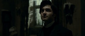 Movie still from “The Woman in Black” (2012), directed by James Watkins – A man in a suit and tie in front of a window; Close Up shot, Low angle