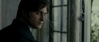 Movie still from “The Woman in Black” (2012), directed by James Watkins – A person wearing a suit near a window; Close Up shot, Over the shoulder angle