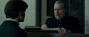 Movie still from “The Woman in Black” (2012), directed by James Watkins – An older man sitting at a table with a woman; Close Up shot, Over the shoulder angle