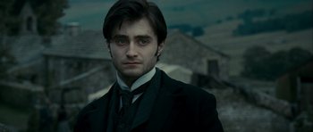 Movie still from “The Woman in Black” (2012), directed by James Watkins – A person wearing a suit and tie; Close Up shot, Over the shoulder angle