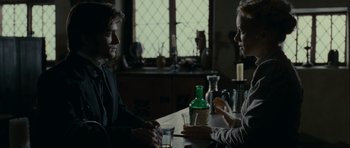Movie still from “The Woman in Black” (2012), directed by James Watkins – A man and a woman sitting at a table with drinks; Medium shot, Over the shoulder angle