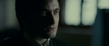 Movie still from “The Woman in Black” (2012), directed by James Watkins – A person wearing a suit and tie; Close Up shot, Over the shoulder angle