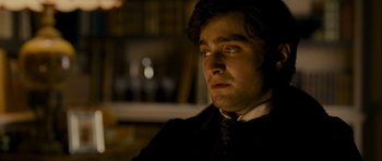 Movie still from “The Woman in Black” (2012), directed by James Watkins – A person wearing a suit and tie; Close Up shot, Over the shoulder angle