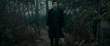Movie still from “The Woman in Black” (2012), directed by James Watkins – A man in a black coat and a dog; Medium shot, High angle