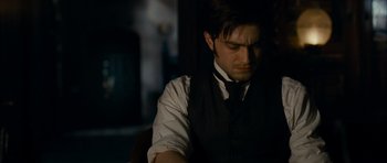Movie still from “The Woman in Black” (2012), directed by James Watkins – A man in a vest and a bow tie looking down; Close Up shot, High angle
