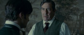 Movie still from “The Woman in Black” (2012), directed by James Watkins – A man wearing a vest and a red tie; Close Up shot, Over the shoulder angle