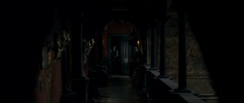 Movie still from “The Woman in Black” (2012), directed by James Watkins – A man standing in front of an open door; Wide shot, High angle