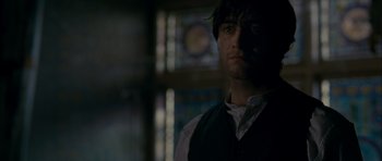 Movie still from “The Woman in Black” (2012), directed by James Watkins – A person wearing a vest in a dark room; Close Up shot, Low angle